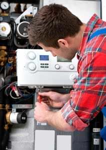 A man working on a tankless water heater