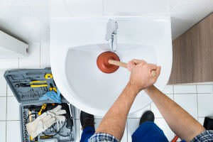 Plumber unclogging a bathroom sink in Buena Park, CA