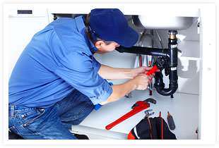 A plumber working under a sink