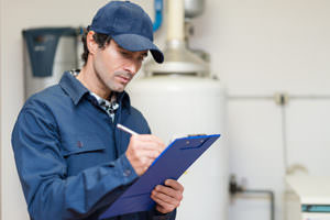 A technician taking notes on a clipboard